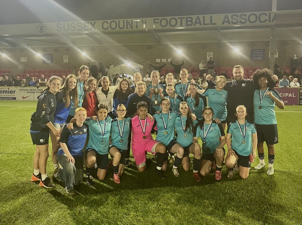 Worthing College Women's football team after winning the county cup. It is night time at the Sussex FA HQ in lancing