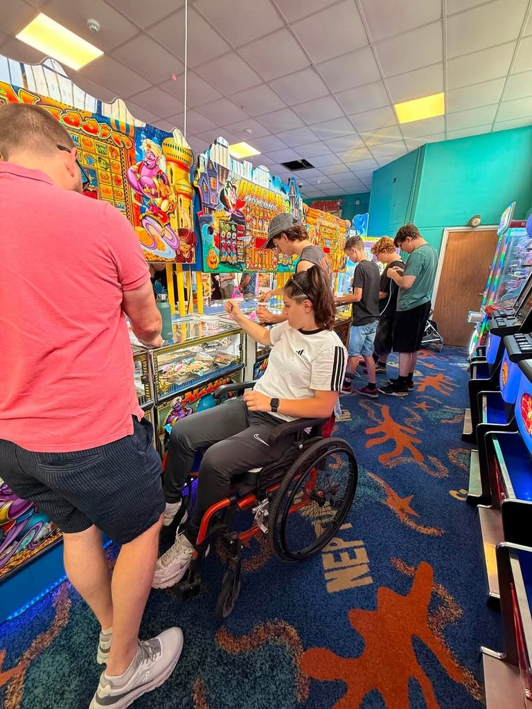 girl in orange wheelchair at arcade