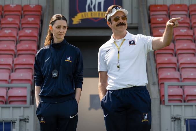 Ted Lasso and Alice Chilton in front of the AFC Richmond tunnel at their training ground